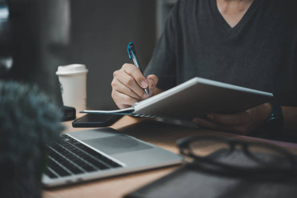istock man hands with pen writing on notebook in the office.learning, education and work.writes goals, plans, make to do and wish list on desk. 1461549331