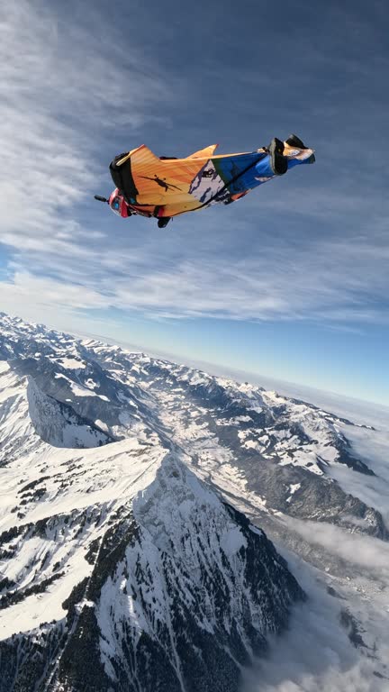 Wingsuit flier soars above Swiss mountain landscape