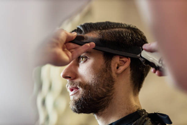 istock Young man having his hair styled by a barber. 1461552787