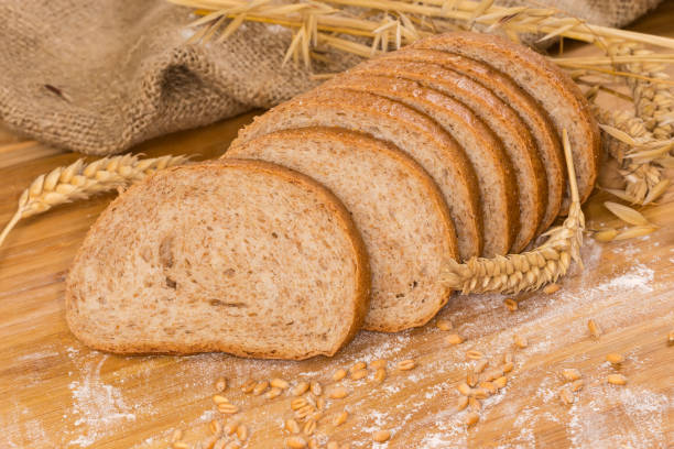 istock Sliced bread with bran among ears, wheat grain and flour 1461553450