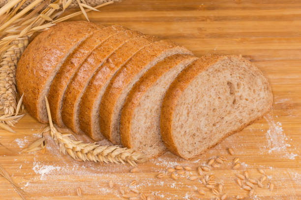 istock Sliced bread with bran among ears, wheat grain and flour 1461553856