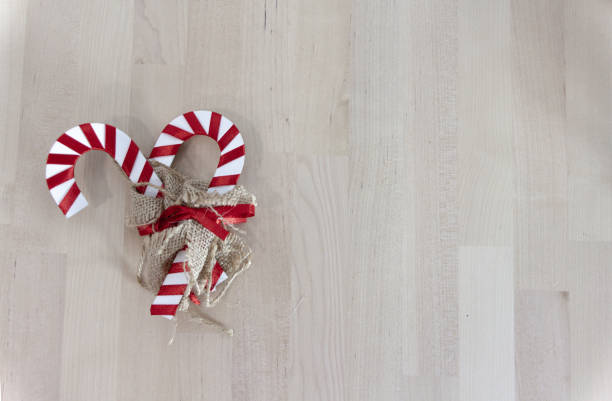 Two decorative candy canes over a wooden table. Christmas background, copy space.