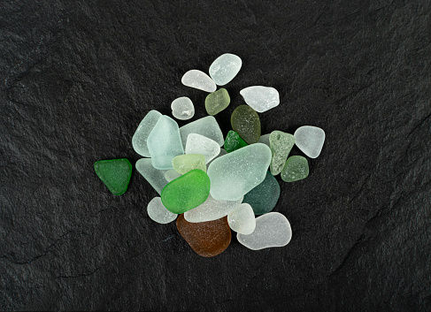 Natural Sea Glass Pile, Beach Glass Stones, Polish Textured Seaglass, Transparent Pebbles on Black Background Top View