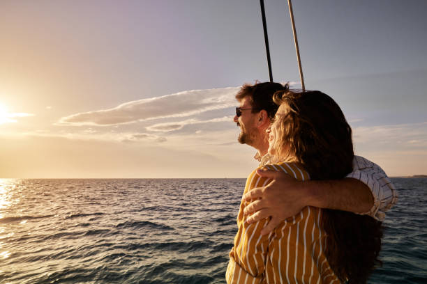 istock Happy embraced couple enjoying on a boat at sunset. 1461555884