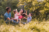 Happy family having fun during spring day in nature.