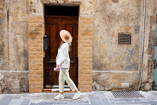 Stylish young woman in front of building entrance