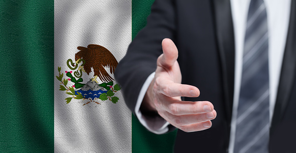 Mexican business, politics, cooperation and travel concept. Hand on flag of Mexico background.