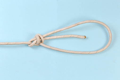 Rope knot double bowline or round turn bowline, view on a blue background