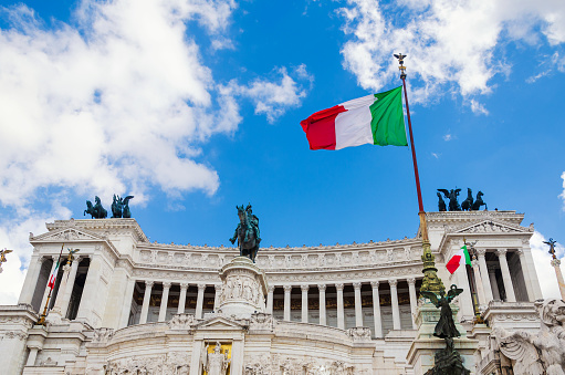 Italian flag on Vittoriano building, Rome, Italy. This monument is landmark of Italy. Sunny view of flag at Capitol hill on Venice Square. Nice scenery