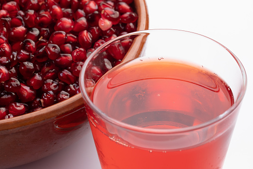Pomegranate fruit grains and juice close upin a glass. Concept of health and wellness