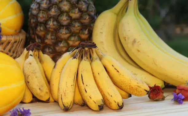 A closeup shot of fresh bananas and pineapples