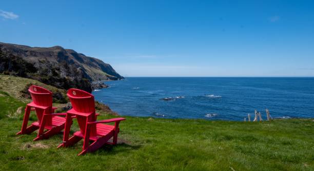 istock Red empty chairs on lush green grass on the seashore in Newfoundland, Canada 1461567655