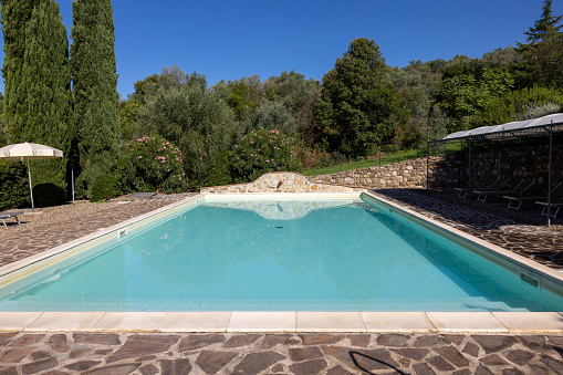 A swimming pool on the Montemassi hillside surrounded by cypresses and oleanders n the province of Grosseto. Italy