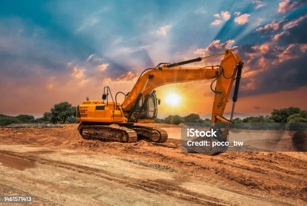 Excavator At Sunset Stock Photo - Download Image Now - Construction Site, Construction Industry, Sunset