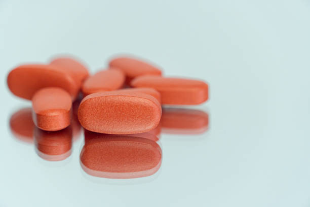 istock Closeup of medical pills on a reflective surface with a blurry background 1461573120