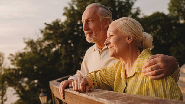 istock Elderly husband hugging wife, enjoying sunset together in park, support 1461575885