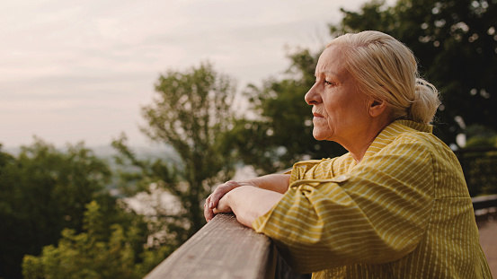 Upset aged woman standing outdoors, loneliness in retirement, problem