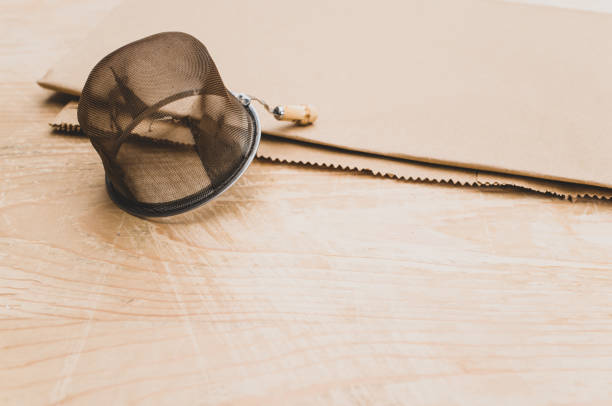 istock worn metal tea strainer on a brown paper and rustic wooden background 1461577047