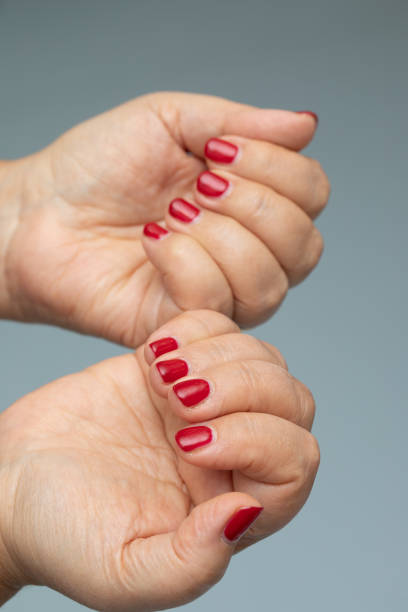 istock Female hands with red manicure isolated on grey background 1461577667