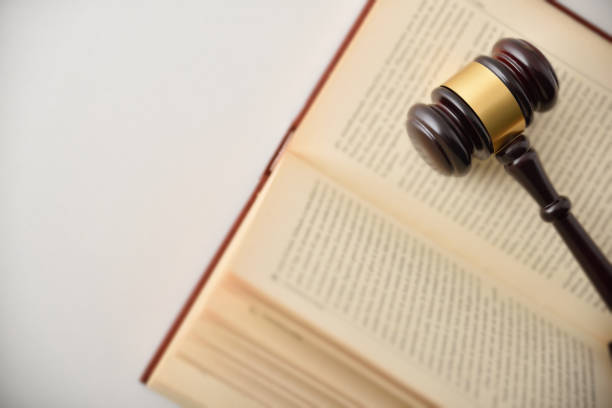 istock Gavel on open law book on white table top view 1461579047