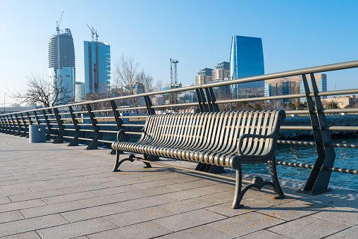 A closeup of a modern bench on the bridge on a view of the city in Baku