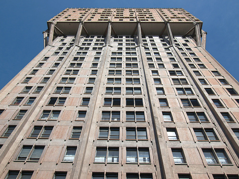 A low angle shot of the Torre Velasca in Milan, Italy under a clear blue