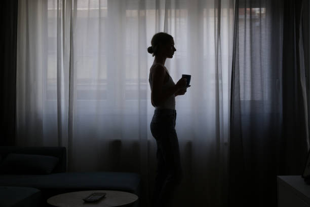 istock Woman drinking coffee next to the window 1461585496