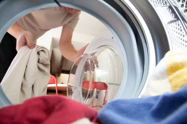istock Person putting laundry inside a drum of a washing machine. 1461586611