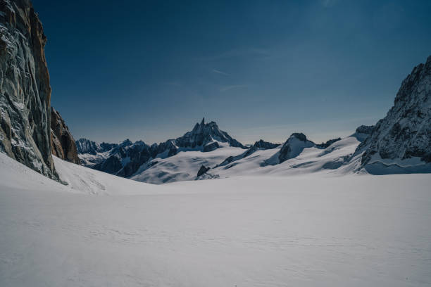 View of glaciers on Mont Blanc Massif and famous peak Dent du Geant, Chamonix, France. High alpine snow covered mountain landscape with creavasses, snow, rock wall and ridge. Alpinism, mountaineering. Dente del Gigante, Courmayer, Italy dent du geant stock pictures, royalty-free photos & images