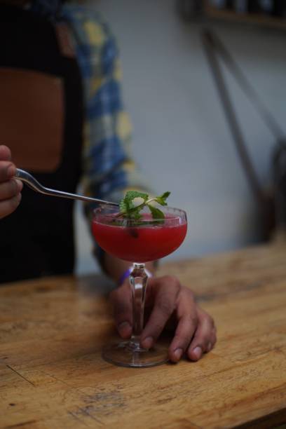 istock Vertical shot of a bartender putting mint on a tasty red cocktail 1461588633