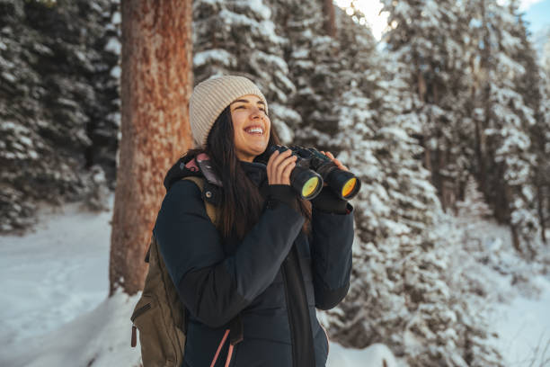 istock Caucasian woman standing by a lake under tree and watching by the binoculars 1461592052