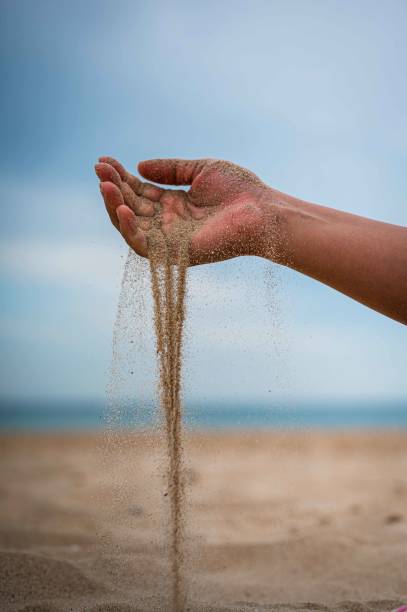 istock Vertical shot of a hand pouring sand on a beach 1461594702