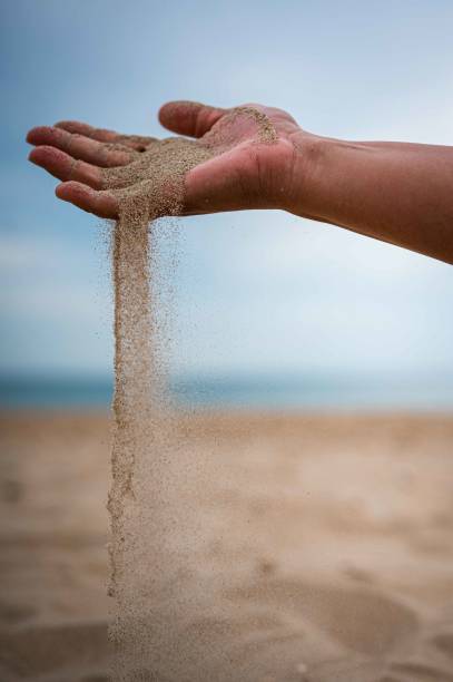 istock Vertical shot of a hand pouring sand on a beach 1461594705