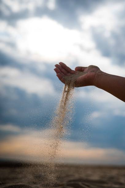 istock Vertical shot of a hand pouring sand on a beach 1461594708