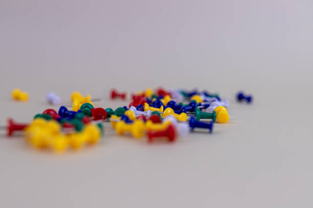 istock Closeup of colorful thumbtacks on a white surface with a blurry background 1461595159