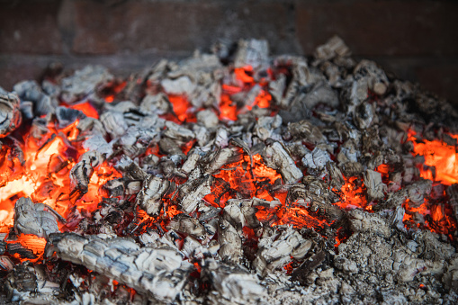 A closeup of burning and flaming hot coal in the fireplace