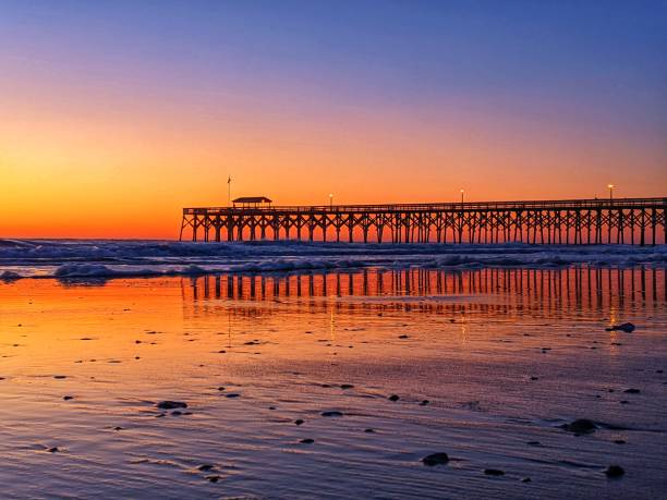 istock Beautiful scenery of a boardwalk on the shore with a sunset background 1461596256