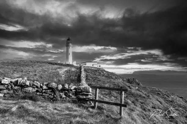 A grayscale shot of the Galloway Lighthouse under a cloudy sky in Scotland