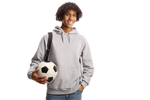 Male african american student with a backpack holding a soccer ball stock photo