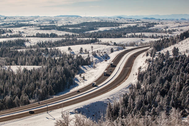 ワイオミング州南部のi-80沿いの雪と高山の木が並ぶ冬の道路の空撮 - laramie ストックフォトと画像