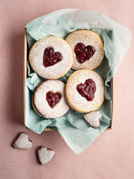 песочное печенье в форме сердца в коробке на розовом фоне, печенье linz (варенье из песочного печенья), печенье с сердцем валентина, печенье с � - marmalade baked biscuit brown стоковые фото и изображения