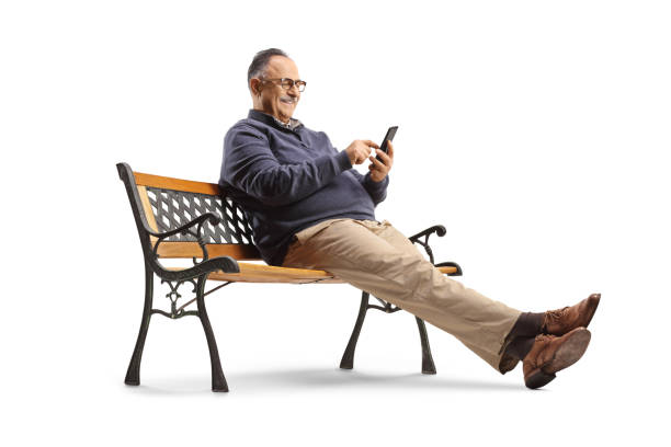 istock Mature man sitting on a bench and using a smartphone 1461601836