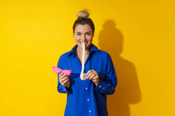 mujer joven probando chicle sobre fondo amarillo - chewing gum women bubble blowing fotografías e imágenes de stock