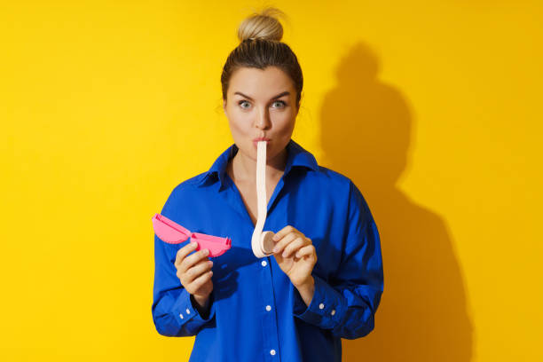 mujer joven probando chicle sobre fondo amarillo - chewing gum women bubble blowing fotografías e imágenes de stock