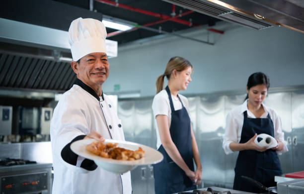 Cooking class atmosphere, Is to work closely with a chef and learn from experienced chefs at recognized institutions. Cooking class atmosphere, Is to work closely with a chef and learn from experienced chefs at recognized institutions. chefs whites stock pictures, royalty-free photos & images