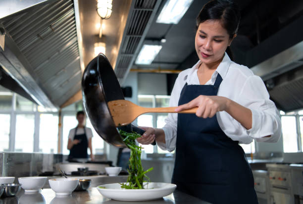 атмосфера кулинарного класса, заключается в том, чтобы тесно сотрудничать с шеф-поваром и учиться у опытных шеф-поваров в признанных заведе - chef trainee cooking teenager стоковые фото и изображения