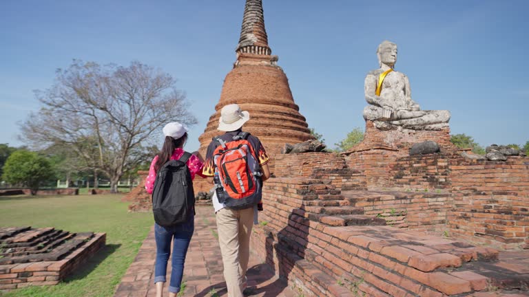 Traveler tourist man and women with backpack walking in historical place temple Ayuttaya Thailand