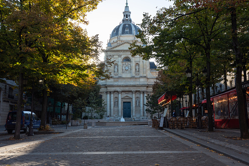 Paris, France - September 17, 2022: Facade of the Sorbonne University building surrounded by trees in the colors of autumn, Paris. France