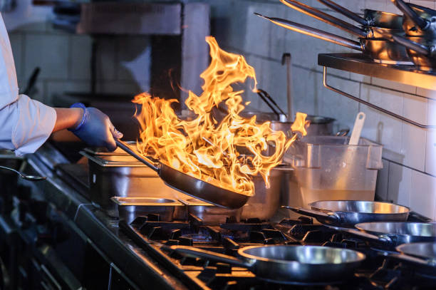 istock Closeup image of chief cook holding roasted meat at open fire grill kitchen background. 1461614865