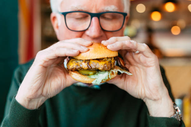 istock Man holding delicious fresh flame grilled burger in restaurant 1461615141